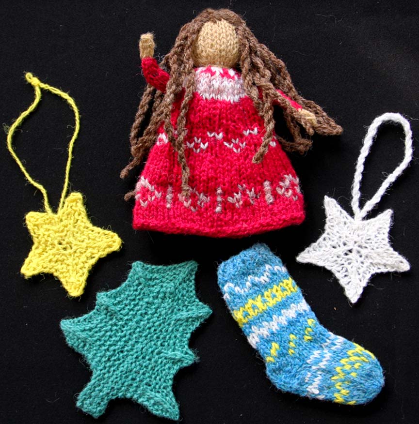 variety of ornaments on black background: tree, doll, stars, stocking