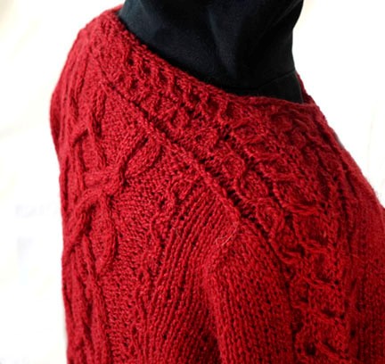 saddle on shoulder of red baroque knitted sweater