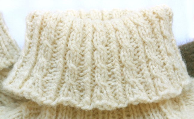 close up of cabled turtleneck in cream