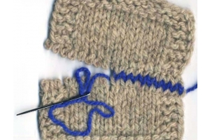gray wool sample that shows half the square woven with blue wool and sewing up needle