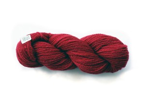 full skein of quebecoise wool in burgundy red, number 55 with sticker tag from the mill, writing on tag is blurred