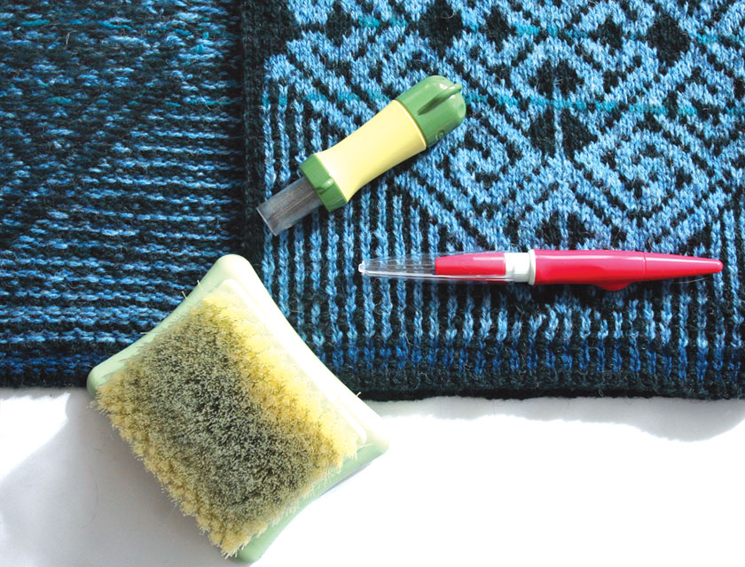 background of the celtic vest sweater with felting tools on top of it