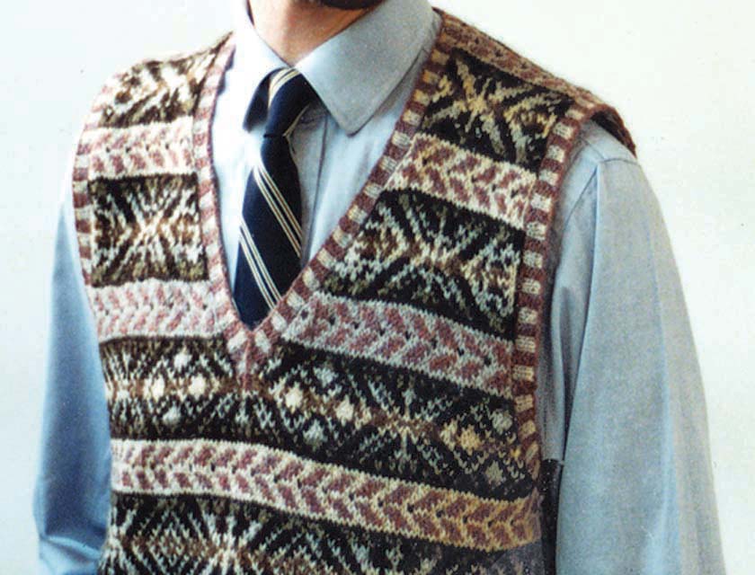Close up of a fair isle vest on a man wearing a shirt and tie, cropped image shows waist to neck only