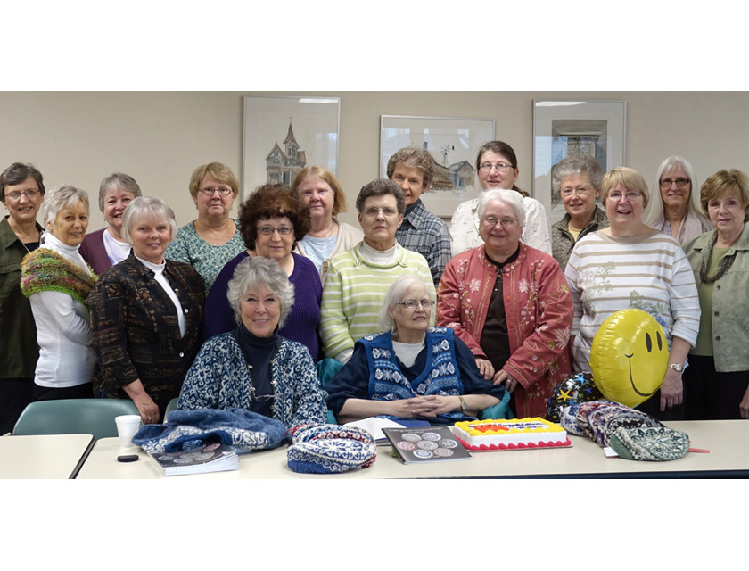 meg swansen and mary rowe, author, seated with guild members standing behind them