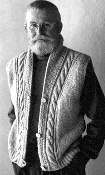 man wearing the natural shawl collared vest with cable detail