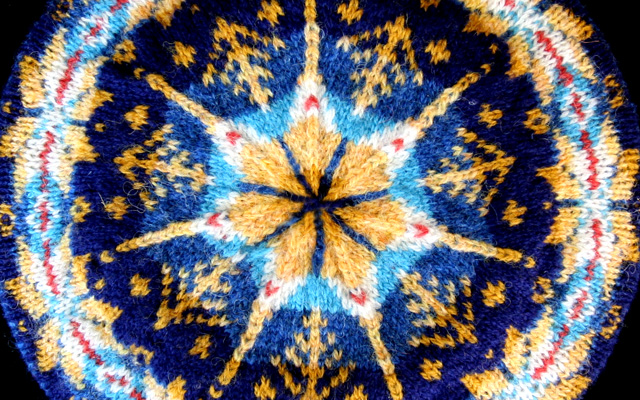 close up of the starry night tam from the book knitting tams, similar colors to Van Gogh Starry night painting--deep blues, yellows