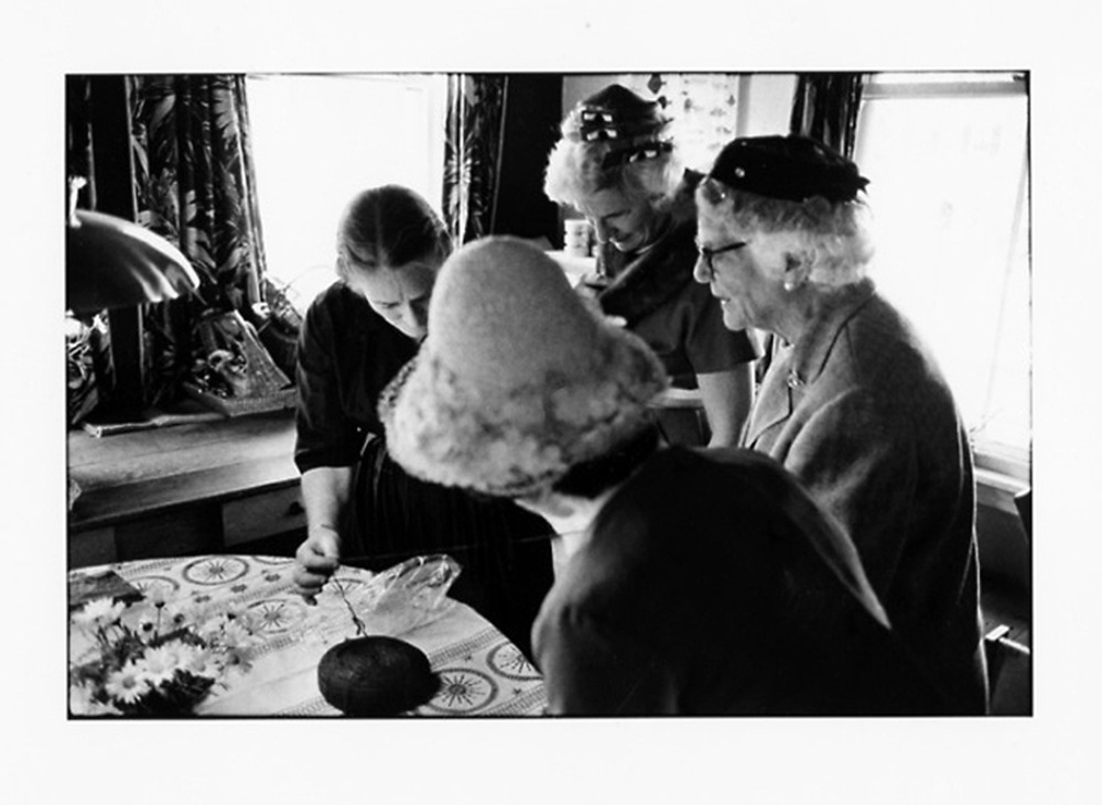 elizabeth zimmermann demonstrates using the center strand from a wheel of unspun icelandic wool, 3 ladies in hats pictured, 1950s
